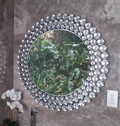 Large round bathroom mirror with beveled mirrored edges.