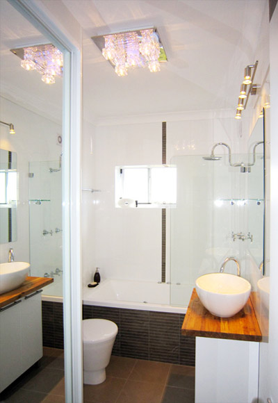 Bathroom: On the left, there is a laundry cabinet hidden inside a closet with mirror door. 